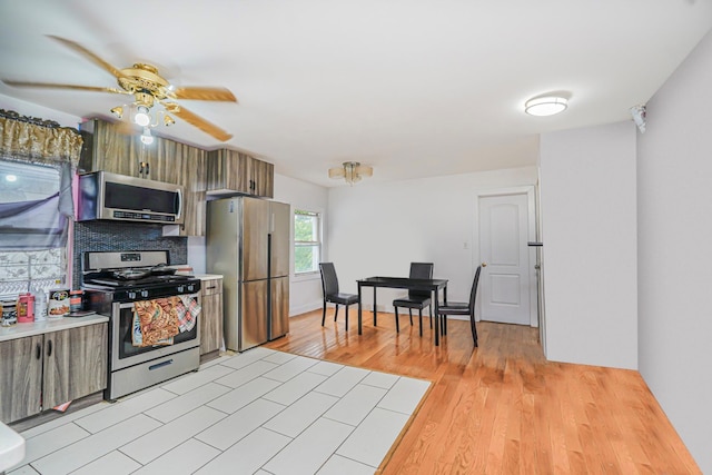 592 E 39th St, Brooklyn, NY 11203 - kitchen featuring stainless steel appliances, ceiling fan, decorative backsplash, light countertops, and light wood-style floors