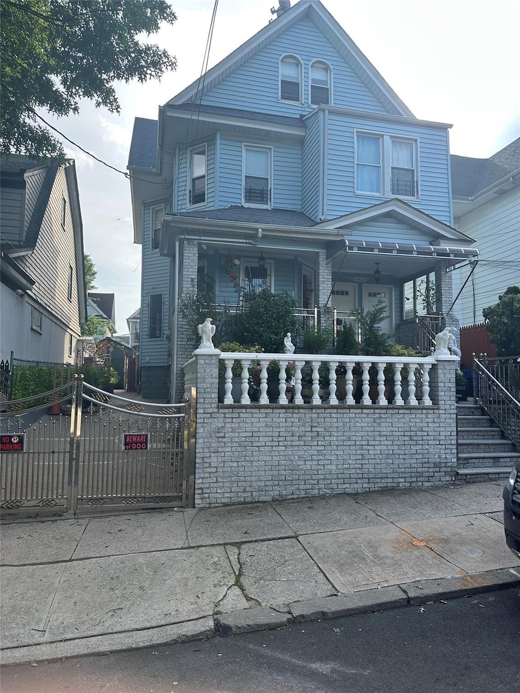 84-28 107th St, Richmond Hill, NY 11418 - view of front of home featuring covered porch, a fenced front yard, and a gate