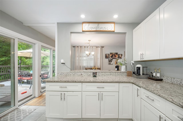 20 Honeymoon Ln, Poughkeepsie, NY 12603 - kitchen with white cabinets, a chandelier, light stone countertops, a peninsula, and recessed lighting