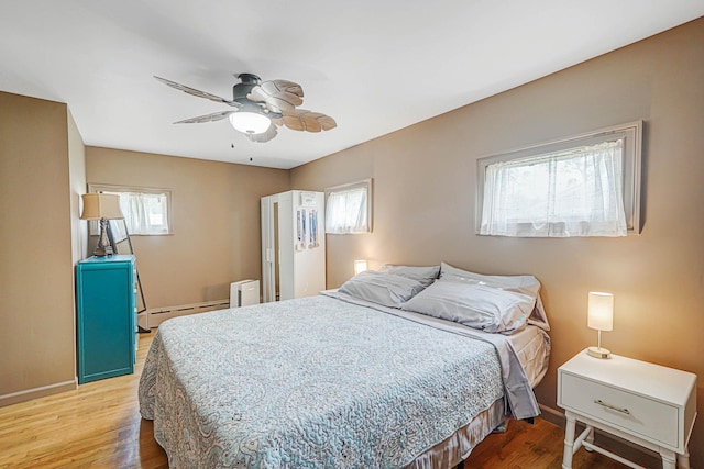 15 Roosevelt Blvd, East Patchogue, NY 11772 - bedroom featuring light wood-style flooring, a ceiling fan, and a baseboard radiator
