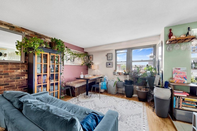 290 W 232nd St Unit 8E, Bronx, NY 10463 - living area featuring wood finished floors, brick wall, and a textured ceiling
