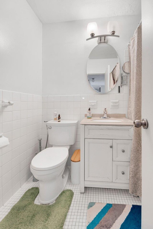 290 W 232nd St Unit 8E, Bronx, NY 10463 - bathroom with vanity, tile patterned floors, tile walls, and wainscoting