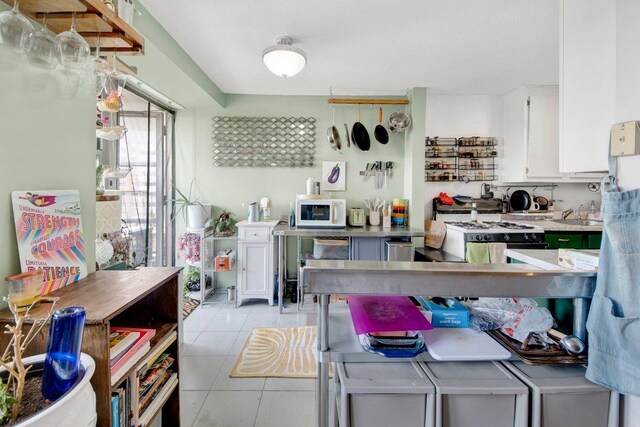 290 W 232nd St Unit 8E, Bronx, NY 10463 - kitchen with white appliances, white cabinets, light tile patterned flooring, and light countertops