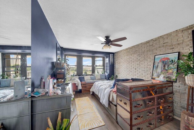 290 W 232nd St Unit 8E, Bronx, NY 10463 - bedroom featuring brick wall, wood finished floors, multiple windows, and a textured ceiling