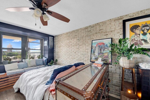 290 W 232nd St Unit 8E, Bronx, NY 10463 - bedroom featuring brick wall, a textured ceiling, wood finished floors, and ceiling fan
