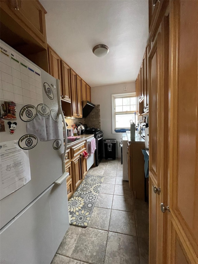 252-23 63rd Ave Unit 1Fl, Little Neck, NY 11362 - kitchen with freestanding refrigerator, brown cabinetry, range, and tasteful backsplash