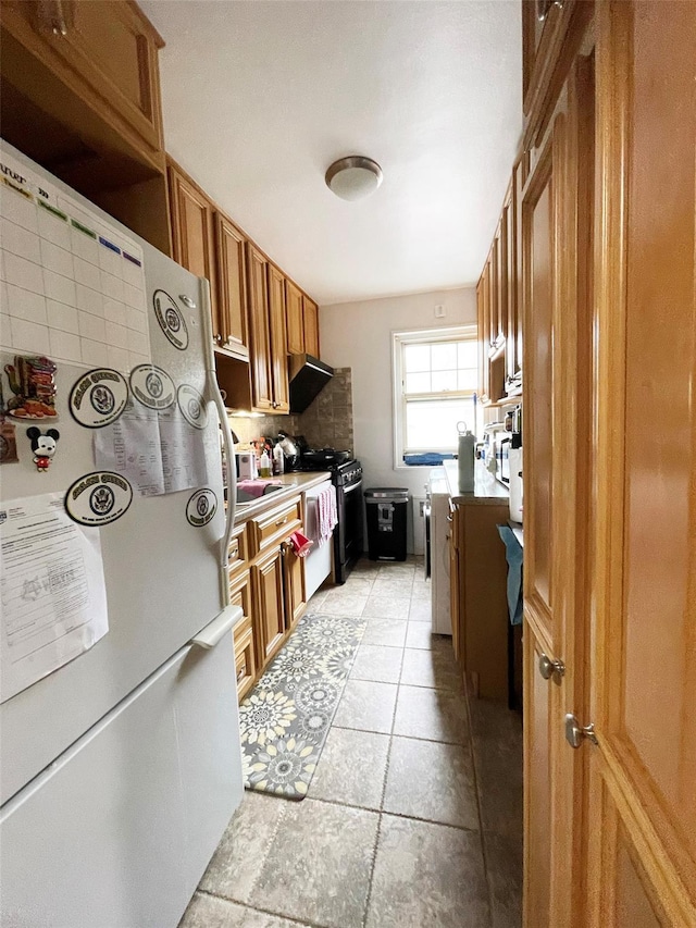 252-23 63rd Ave Unit 1081, Little Neck, NY 11362 - kitchen with freestanding refrigerator, brown cabinetry, stove, light countertops, and tasteful backsplash