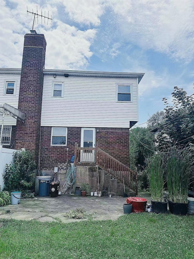 141-31 25th Rd, Flushing, NY 11354 - back of house featuring brick siding, a chimney, and a lawn