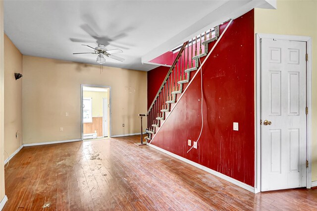 89 Circuit Rd, Bellport, NY 11713 - unfurnished living room featuring stairs, ceiling fan, wood-type flooring, and baseboard heating