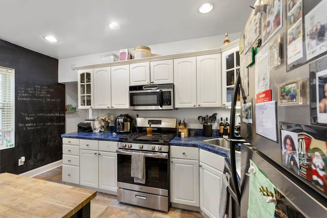 3046 Coddington Ave, Bronx, NY 10461 - kitchen with stainless steel appliances, dark countertops, glass insert cabinets, white cabinets, and recessed lighting