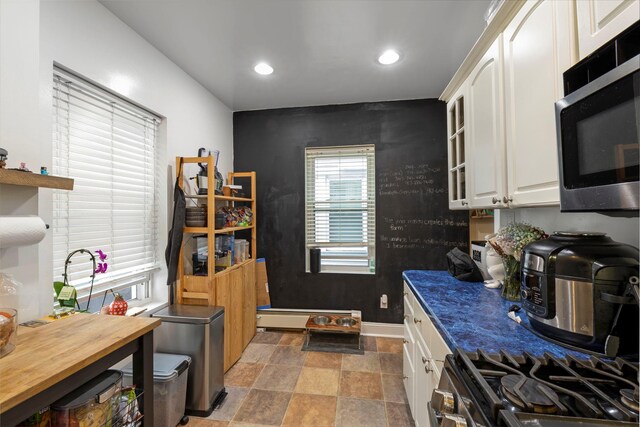 3046 Coddington Ave, Bronx, NY 10461 - kitchen featuring black microwave, stone finish flooring, white cabinets, recessed lighting, and gas range