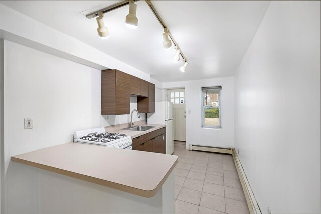 3046 Coddington Ave, Bronx, NY 10461 - kitchen featuring white appliances, a baseboard heating unit, light countertops, light tile patterned floors, and track lighting