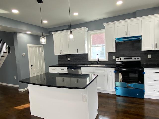 6 Elbert St, Call Listing Agent, NY 12304 - kitchen featuring electric range, under cabinet range hood, dark wood-type flooring, stainless steel dishwasher, and white cabinetry