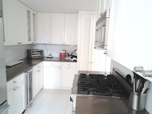 200 E 66th St Unit B1503, New York Manhattan, NY 10065 - kitchen with stainless steel appliances, dark countertops, wine cooler, and decorative backsplash