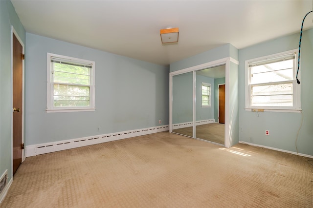 615 E Olive St, Long Beach, NY 11561 - unfurnished bedroom featuring multiple windows, carpet floors, a baseboard radiator, and a closet