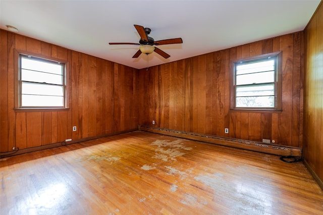615 E Olive St, Long Beach, NY 11561 - unfurnished room featuring light wood finished floors, ceiling fan, a baseboard radiator, and wooden walls