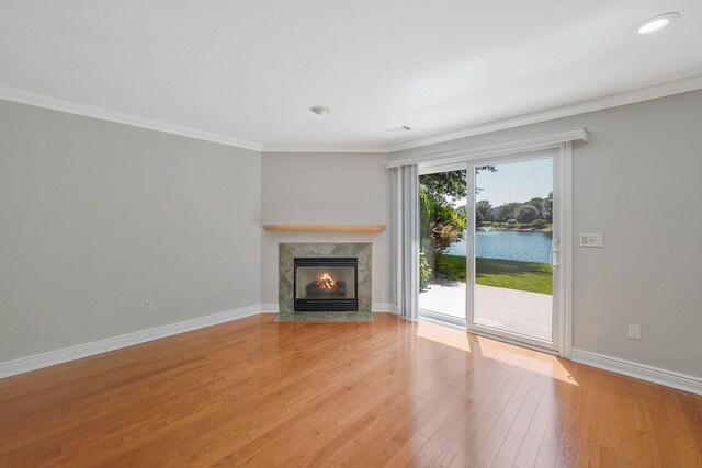 86 Erik Dr, East Setauket, NY 11733 - unfurnished living room featuring a water view, a high end fireplace, light wood-type flooring, and ornamental molding
