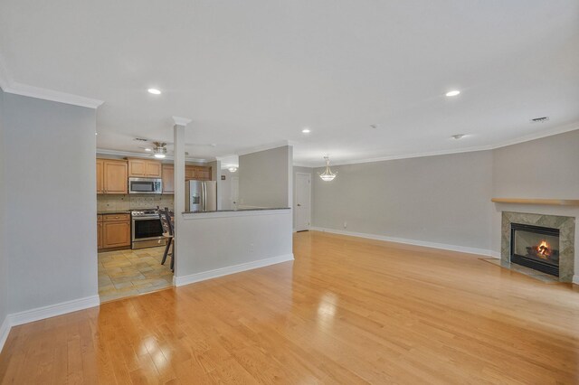 86 Erik Dr, East Setauket, NY 11733 - unfurnished living room featuring crown molding, a ceiling fan, a fireplace, light wood-type flooring, and recessed lighting