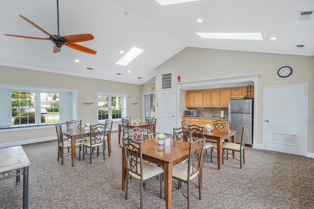 86 Erik Dr, East Setauket, NY 11733 - dining space featuring a skylight, light colored carpet, recessed lighting, high vaulted ceiling, and a ceiling fan