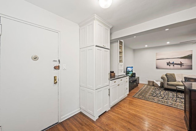9707 4th Ave Unit 3R, Brooklyn, NY 11209 - kitchen with wood finished floors, white cabinetry, open floor plan, dark countertops, and recessed lighting