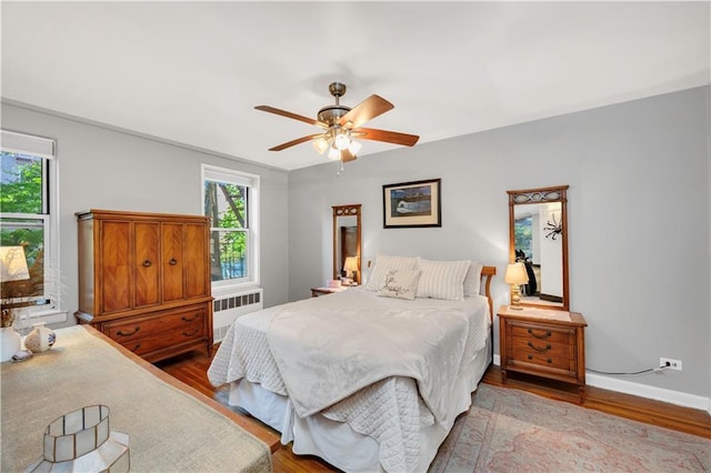 9707 4th Ave Unit 3R, Brooklyn, NY 11209 - bedroom featuring radiator heating unit, wood finished floors, and a ceiling fan