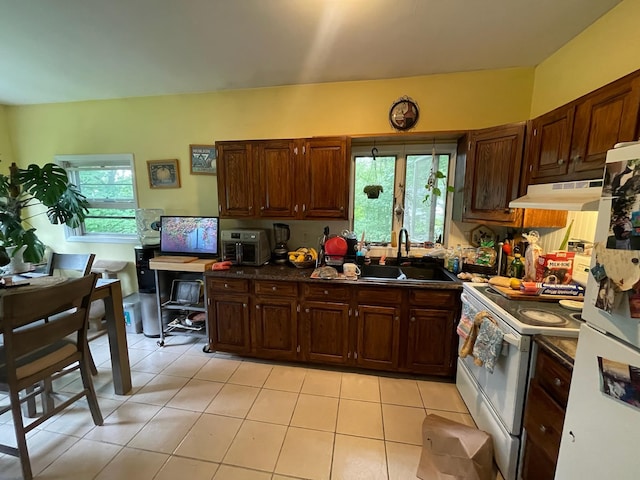 126 Tanglewylde Rd, Lake Peekskill, NY 10579 - kitchen with under cabinet range hood, white appliances, dark countertops, and plenty of natural light