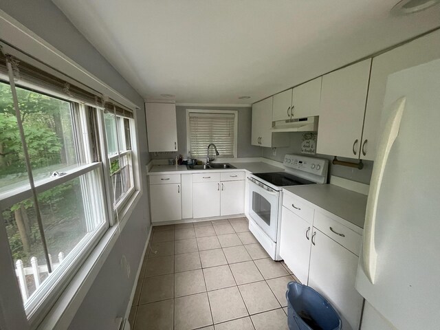 126 Tanglewylde Rd, Lake Peekskill, NY 10579 - kitchen with white appliances, under cabinet range hood, light tile patterned flooring, and white cabinetry