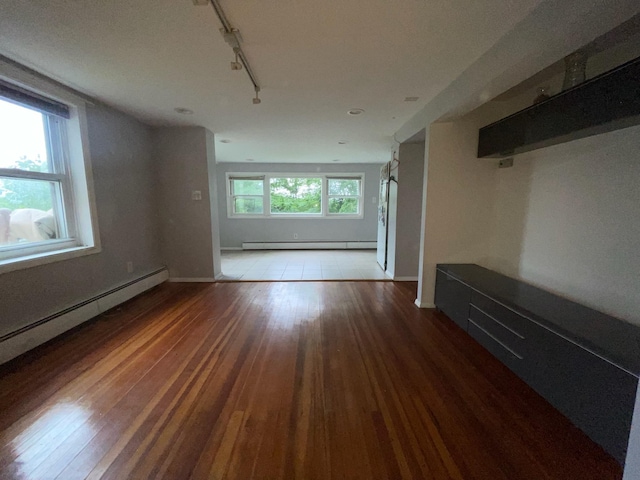 126 Tanglewylde Rd, Lake Peekskill, NY 10579 - unfurnished living room featuring a baseboard heating unit, rail lighting, and wood finished floors