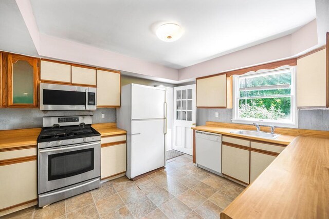 4 Cooks Ln, Westhampton, NY 11977 - kitchen with stainless steel appliances, tasteful backsplash, wooden counters, and stone finish floors
