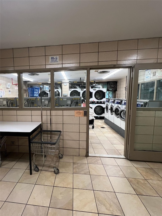 1815 215th St Unit 1G, Flushing, NY 11360 - interior space featuring stacked washer / dryer, light tile patterned floors, tile walls, and washer and dryer