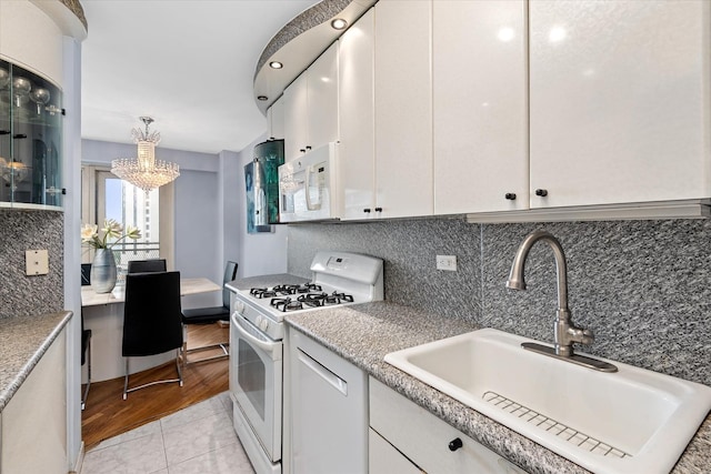 2928 W 5th St Unit 10P, Brooklyn, NY 11224 - kitchen with white appliances, a chandelier, backsplash, and light countertops