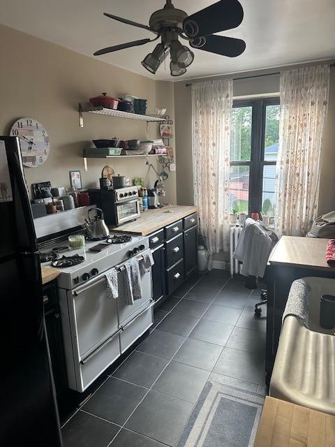 240 Alpine Pl Unit 2A, Eastchester, NY 10707 - kitchen with gas range gas stove, freestanding refrigerator, ceiling fan, dark cabinetry, and open shelves