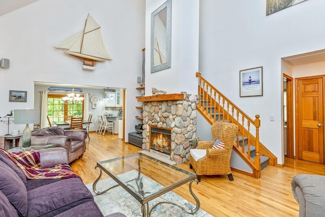 600 Shipyard Ln, East Marion, NY 11939 - living room featuring a towering ceiling, a chandelier, wood finished floors, stairs, and a fireplace