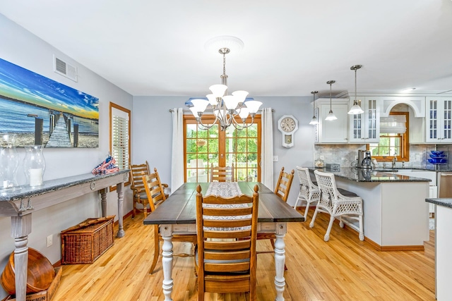 600 Shipyard Ln, East Marion, NY 11939 - dining room featuring a chandelier, light wood-style floors, and healthy amount of natural light