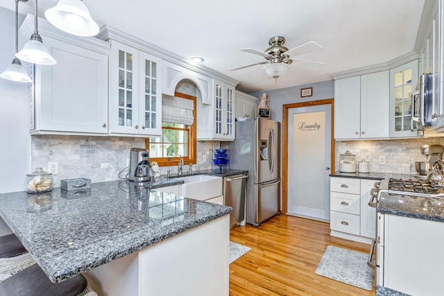 600 Shipyard Ln, East Marion, NY 11939 - kitchen with stainless steel appliances, a peninsula, ceiling fan, a kitchen breakfast bar, and light wood finished floors