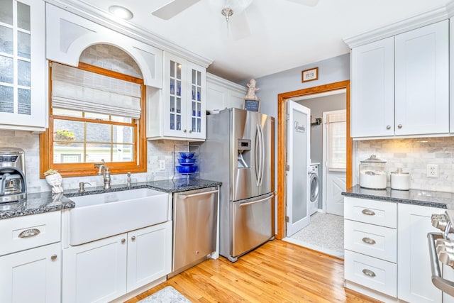 600 Shipyard Ln, East Marion, NY 11939 - kitchen with stainless steel appliances, washer / clothes dryer, decorative backsplash, and white cabinetry