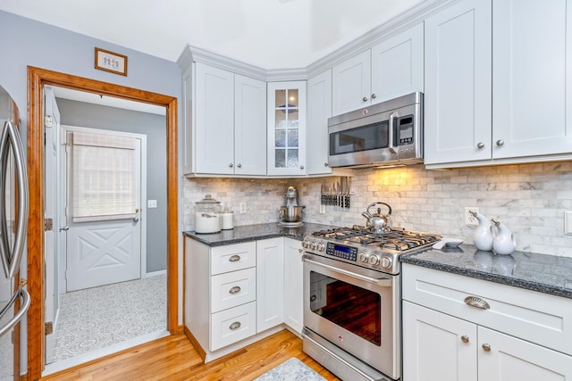 600 Shipyard Ln, East Marion, NY 11939 - kitchen featuring appliances with stainless steel finishes, dark stone countertops, tasteful backsplash, and white cabinets