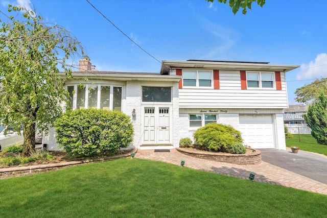 790 Adams St, Baldwin, NY 11510 - tri-level home featuring asphalt driveway, brick siding, an attached garage, a front lawn, and a chimney