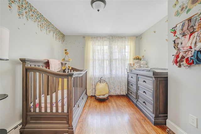 5 Fox Rd, Middle Island, NY 11953 - bedroom featuring a baseboard radiator, wood finished floors, and a nursery area