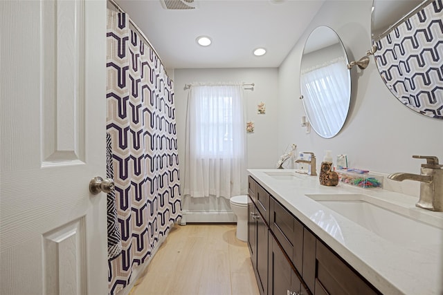 5 Fox Rd, Middle Island, NY 11953 - full bathroom with double vanity, recessed lighting, wood finished floors, curtained shower, and baseboard heating
