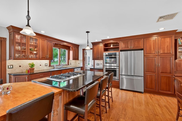 19 Ridgeview Ter, Goshen, NY 10924 - kitchen featuring stainless steel appliances, open shelves, hanging light fixtures, light wood-style floors, and a kitchen bar