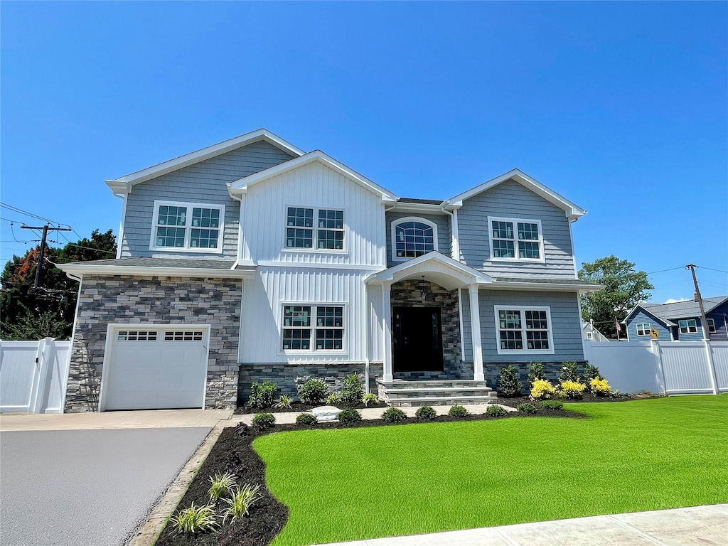 60 Schoolhouse Rd, Levittown, NY 11756 - craftsman inspired home featuring stone siding, an attached garage, and driveway