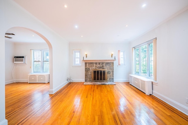 6419 Fitchett St, Rego Park, NY 11374 - unfurnished living room featuring radiator, plenty of natural light, light wood-style flooring, ornamental molding, and arched walkways