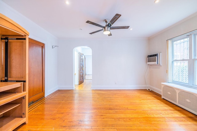 6419 Fitchett St, Rego Park, NY 11374 - empty room featuring radiator, arched walkways, light wood-type flooring, a wall mounted AC, and a ceiling fan