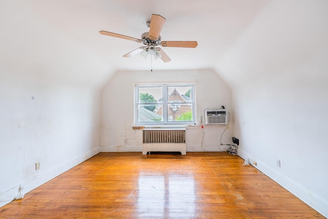6419 Fitchett St, Rego Park, NY 11374 - additional living space with radiator heating unit, vaulted ceiling, ceiling fan, wood finished floors, and an AC wall unit