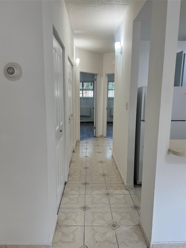 889 E 169th St, Bronx, NY 10459 - hallway featuring a textured ceiling and baseboards