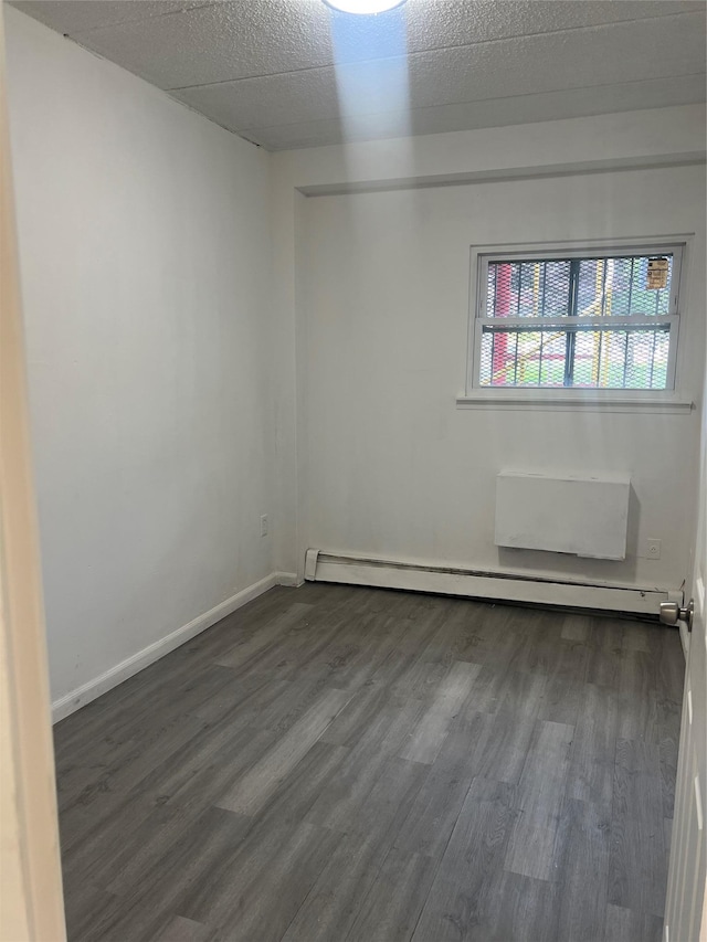 889 E 169th St, Bronx, NY 10459 - empty room with a baseboard radiator and dark wood finished floors