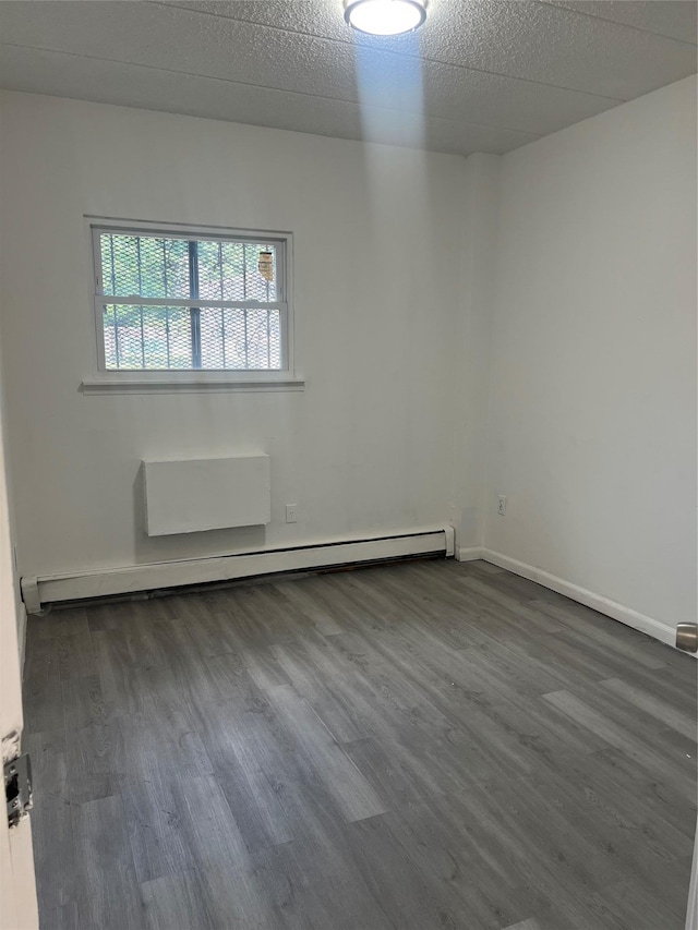 889 E 169th St, Bronx, NY 10459 - unfurnished room featuring baseboard heating and dark wood-type flooring