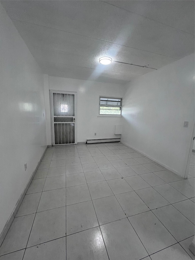 889 E 169th St, Bronx, NY 10459 - spare room featuring a baseboard radiator and light tile patterned flooring