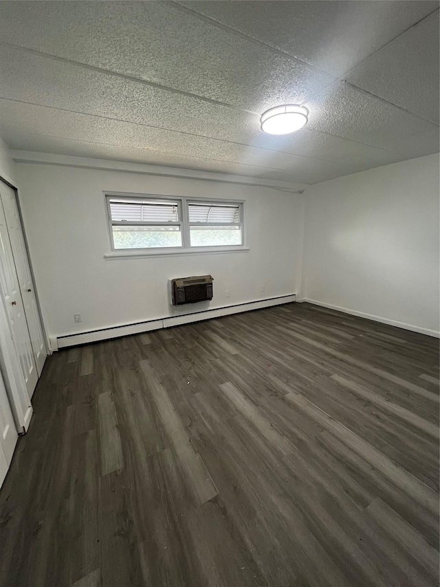 889 E 169th St, Bronx, NY 10459 - unfurnished bedroom with dark wood-style floors, a baseboard heating unit, a wall unit AC, and a closet